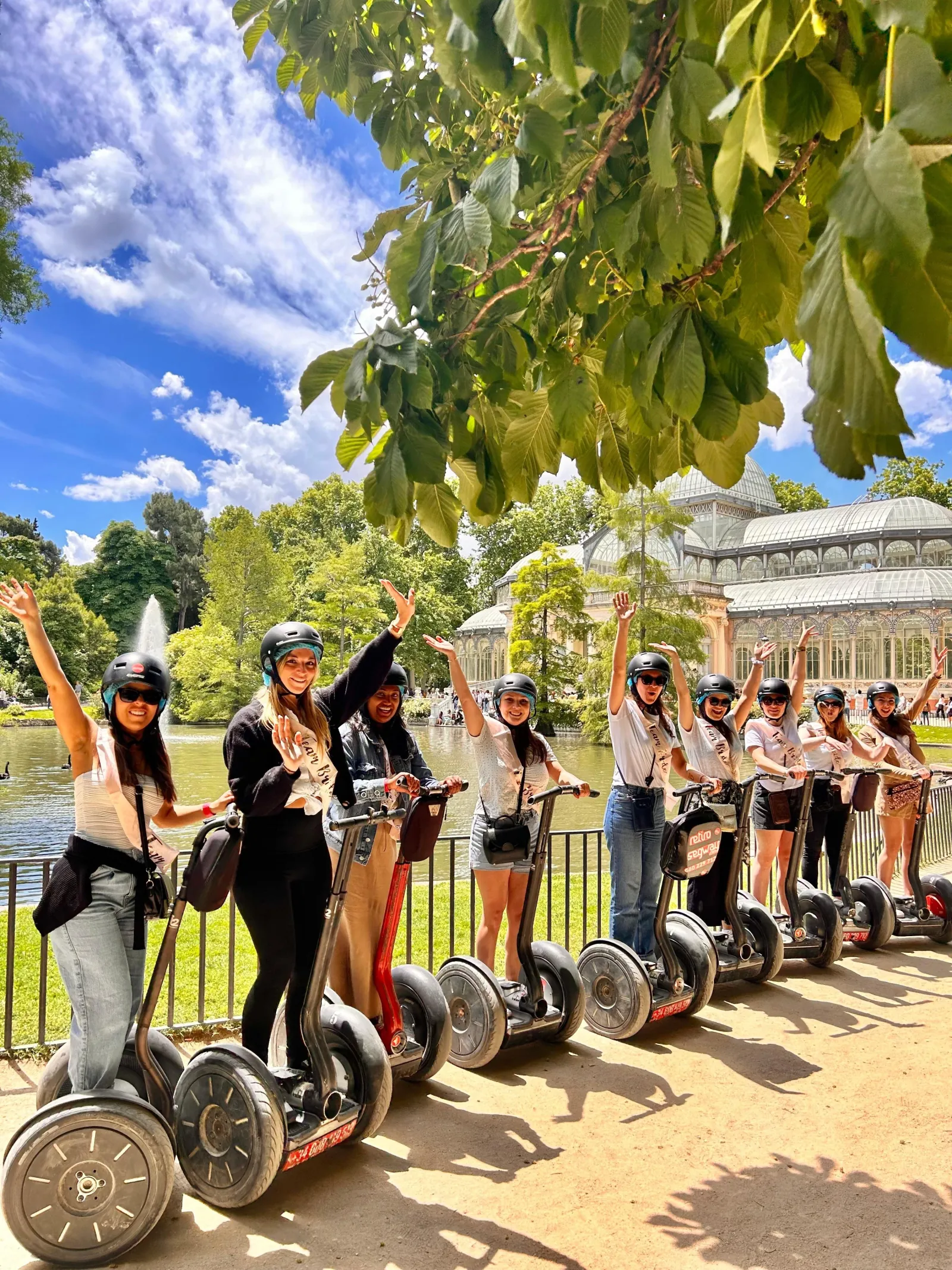 Group of riders on Segways on a tree-lined path in Retiro Park, Madrid