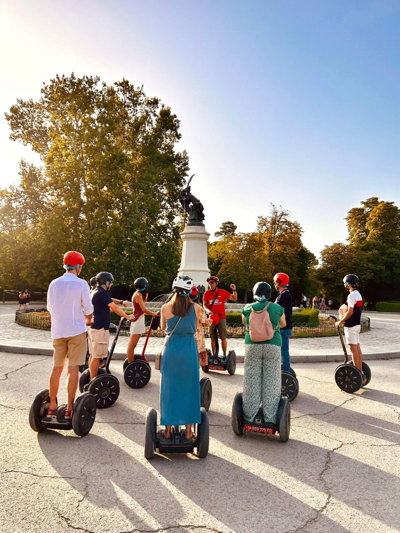 Segway riders in low autumn sun on a Retiro Park avenue
