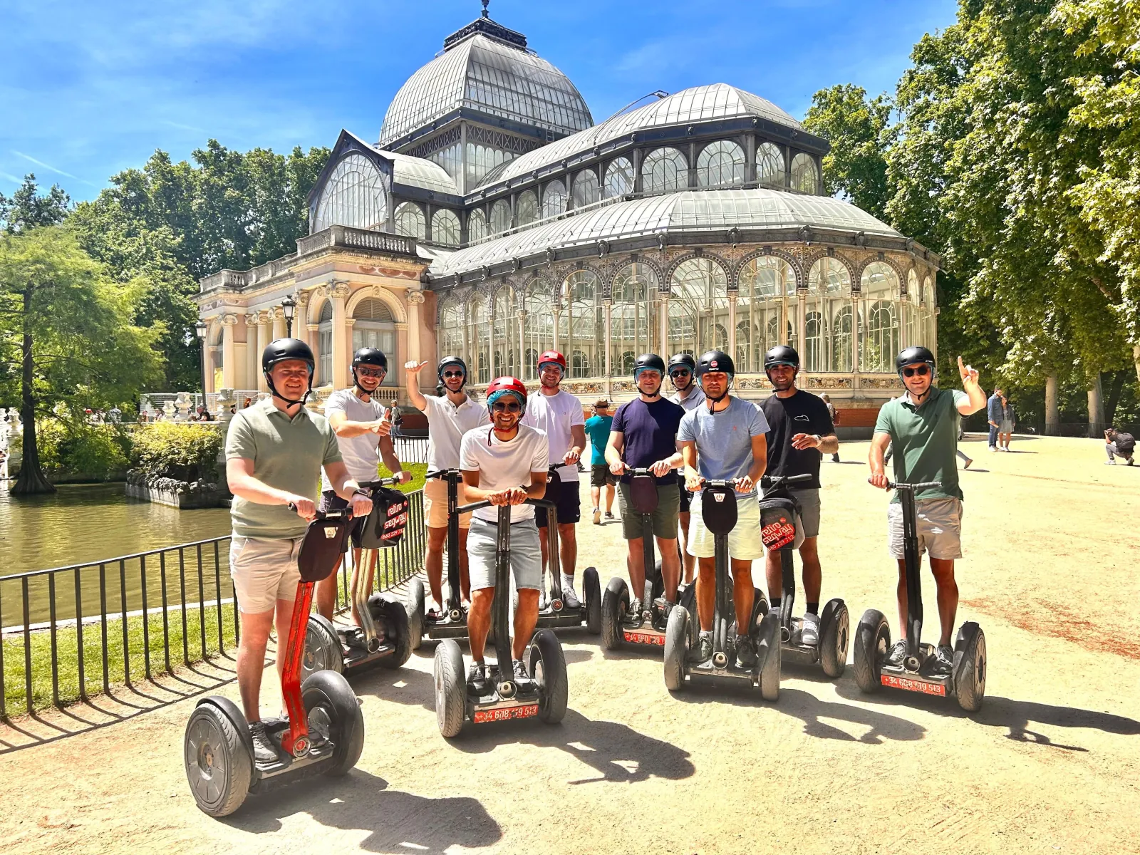 Segway tour group posed in front of the Palacio de Cristal in Retiro Park
