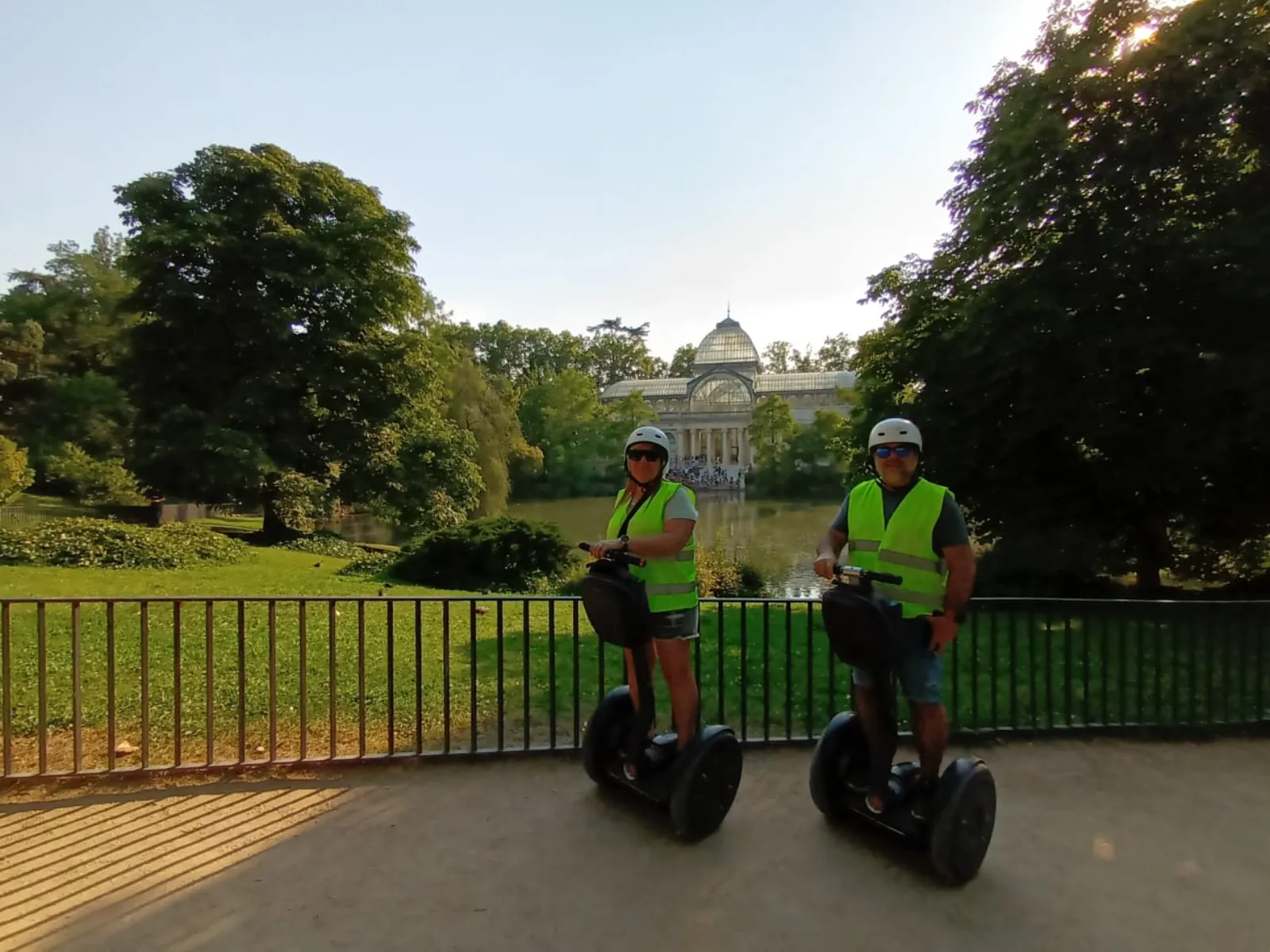 Riders on Segways on a tree-lined path in Retiro Park
