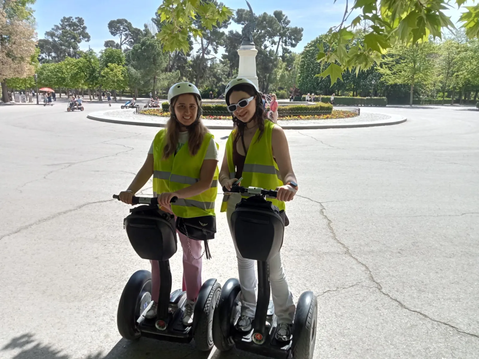 Two riders on Segways on a park path in Madrid