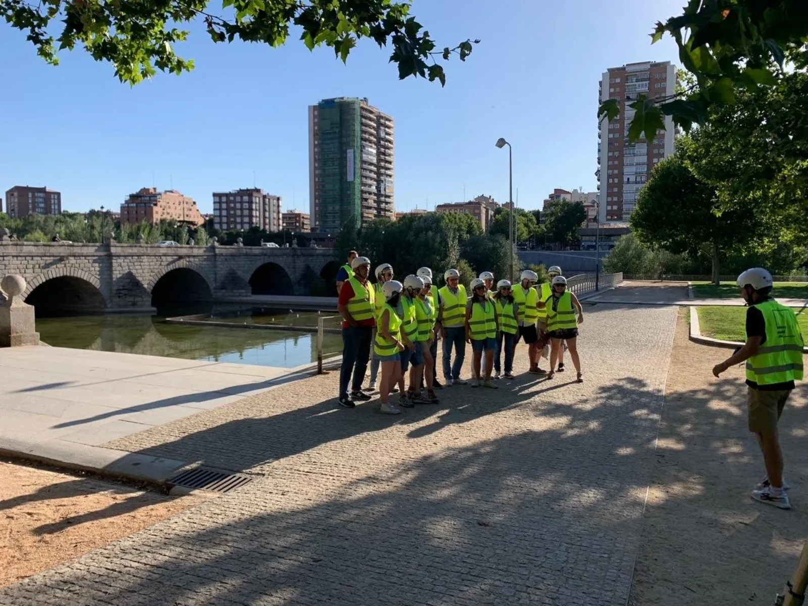 Segway group beside the Manzanares with the Madrid skyline behind