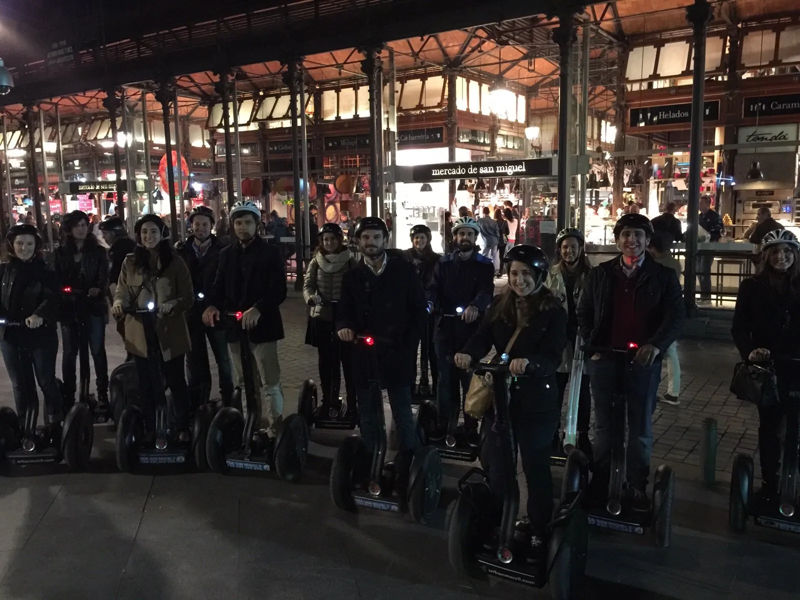 Segway group under a lit arcade in Madrid after dark
