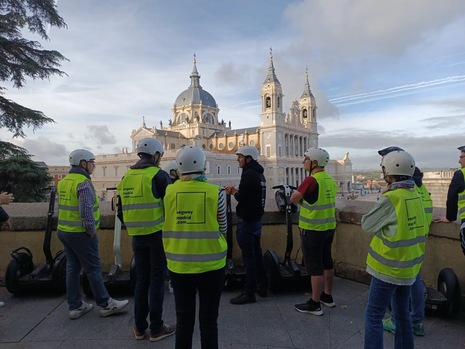 Riders on Segways looking up at the Almudena Cathedral dome