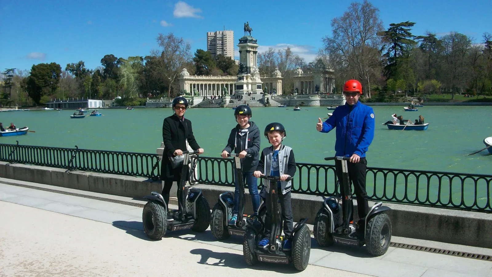 Riders on Segways beside the Retiro lake and the Alfonso XII monument