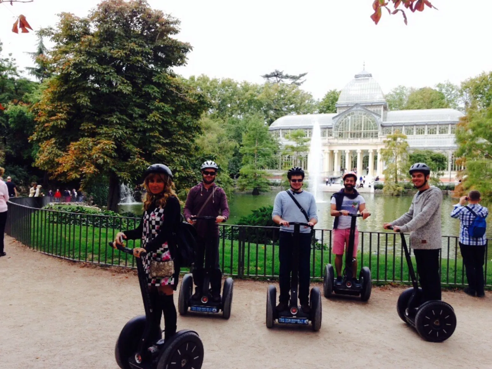 Riders on Segways by the Palacio de Cristal pond in Retiro Park