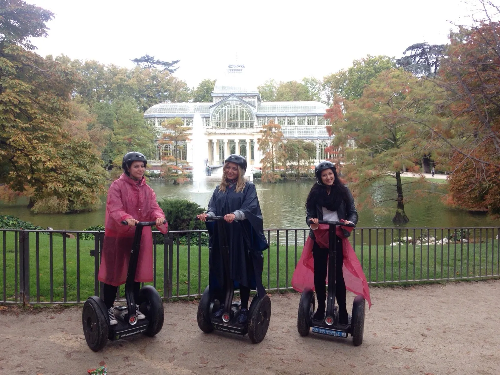 Riders in bright coats on Segways beside the Retiro lake