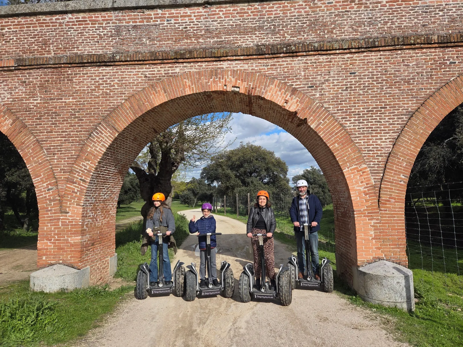 Segway group under a brick arch on a Casa de Campo track